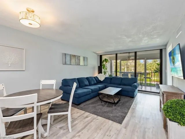 Living room with light wood-style flooring and floor to ceiling windows