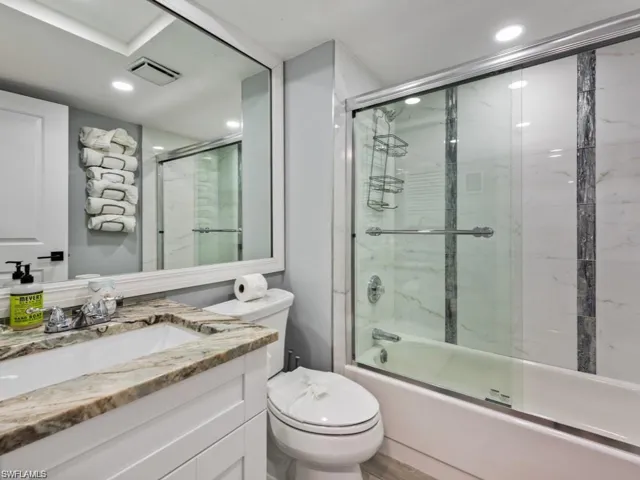 Full bathroom with vanity, recessed lighting, and bath / shower combo with glass door