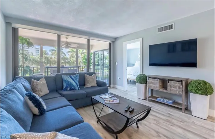 Living room with light wood-style flooring and a ceiling fan