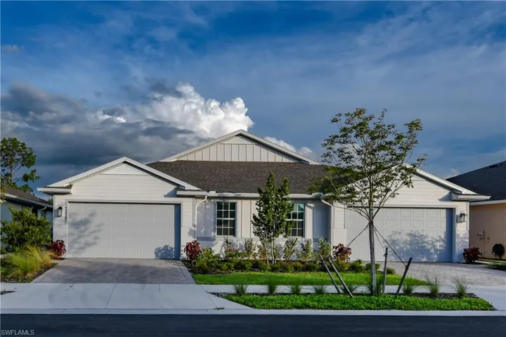 Ranch-style home featuring decorative driveway, a shingled roof, and an attached garage