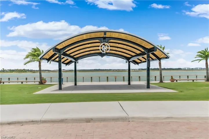 View of home's community with a lawn, a water view, and a patio area