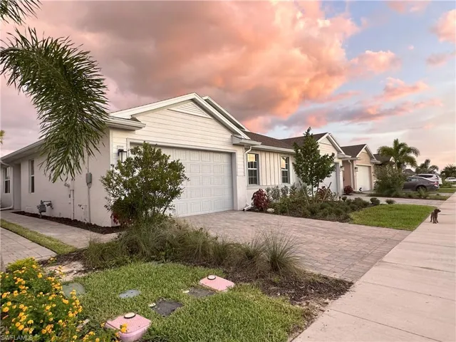 Ranch-style home featuring decorative driveway and an attached garage
