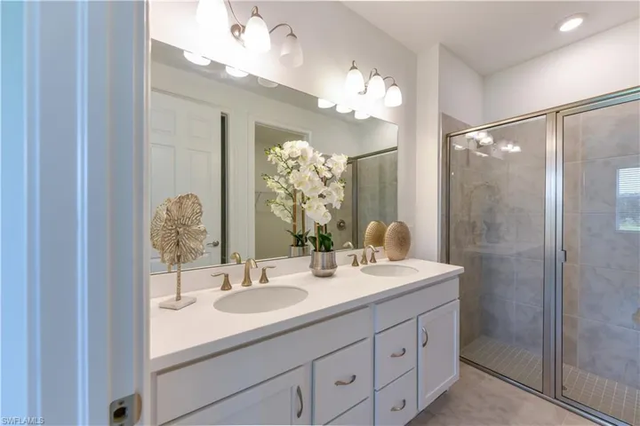 Full bathroom featuring a shower stall and double vanity