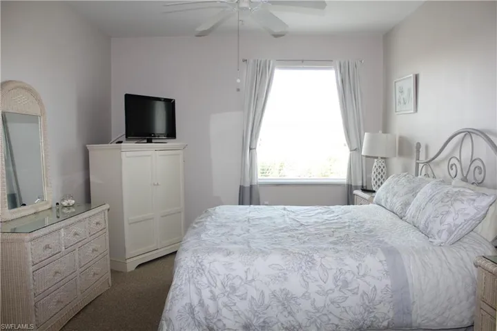 Bedroom featuring dark carpet and a ceiling fan