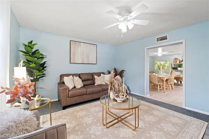 Carpeted living room with ceiling fan