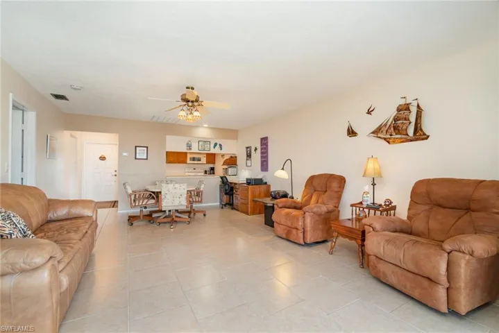 Open-concept living area featuring light-toned tile flooring throughout