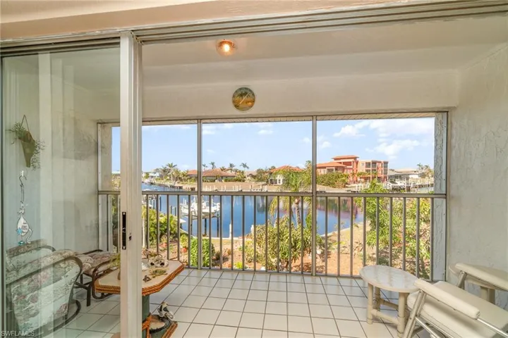 Screened balcony featuring white square tile flooring and a water vista