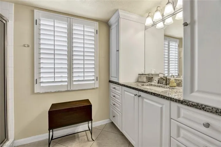 lovely vanity with granite counters and additional cabinets