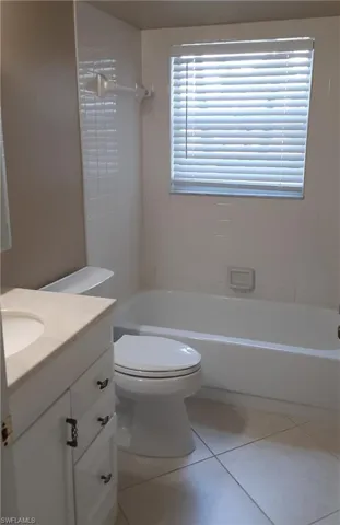 Full bathroom with a healthy amount of sunlight, toilet, vanity, and tiled shower / bath