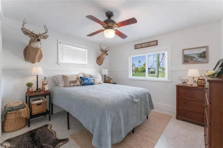 Bedroom with a ceiling fan and dark speckled floor