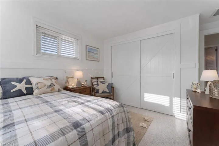 Bedroom with a closet and dark aggregate flooring