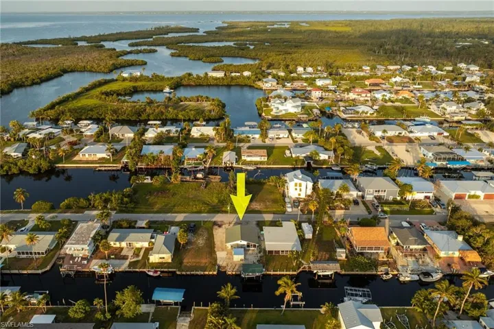 Aerial view of property and surrounding area with a nearby body of water and nearby suburban area