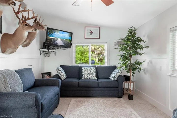 Living area with speckle patterned floor and a ceiling fan