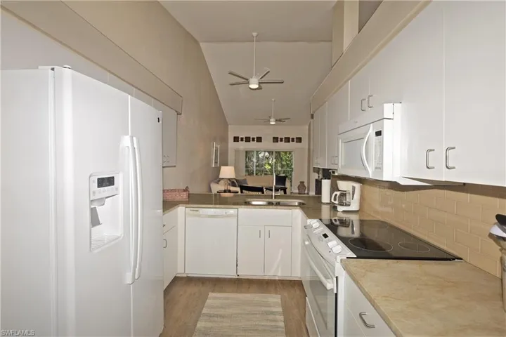 Kitchen featuring  wood-style tile flooring, subway backsplash, Quartz countertops and ceiling fan