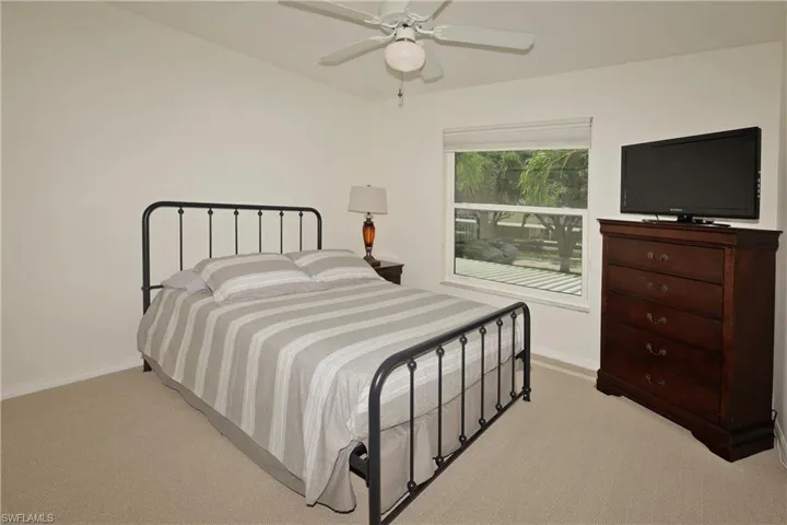 Guest bedroom with newly carpeted flooring and ceiling fan