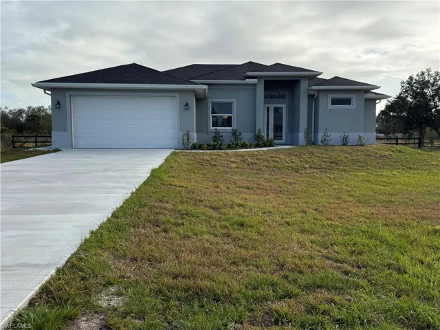 Prairie-style house featuring stucco siding, driveway, and a garage