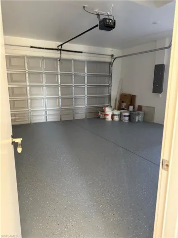 Garage featuring electric panel and a garage door opener