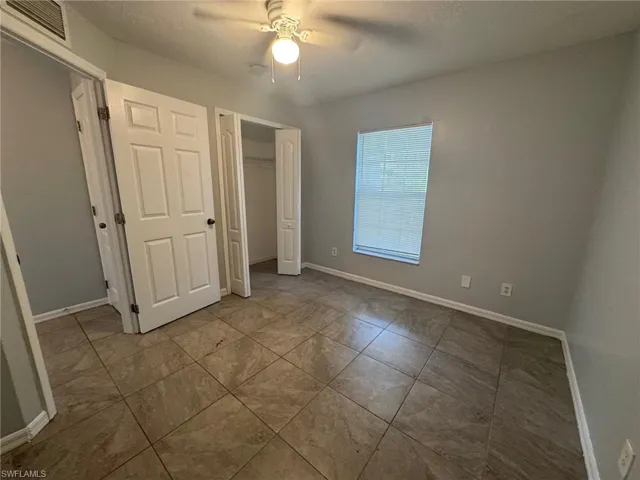 Unfurnished bedroom with a ceiling fan and a closet