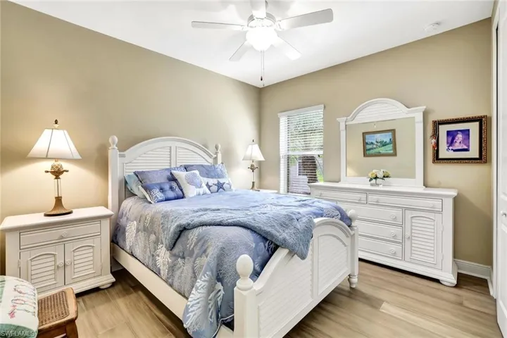 Bedroom featuring a ceiling fan, light wood-style flooring, and baseboards