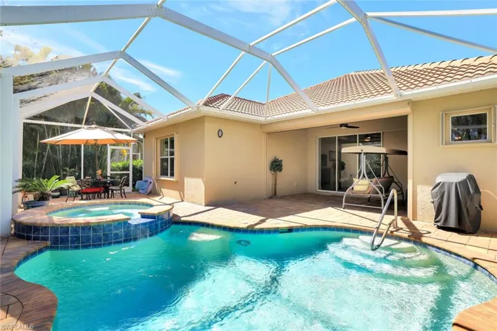 View of swimming pool with a patio area, a sunroom, a ceiling fan, a pool with connected hot tub, and a grill