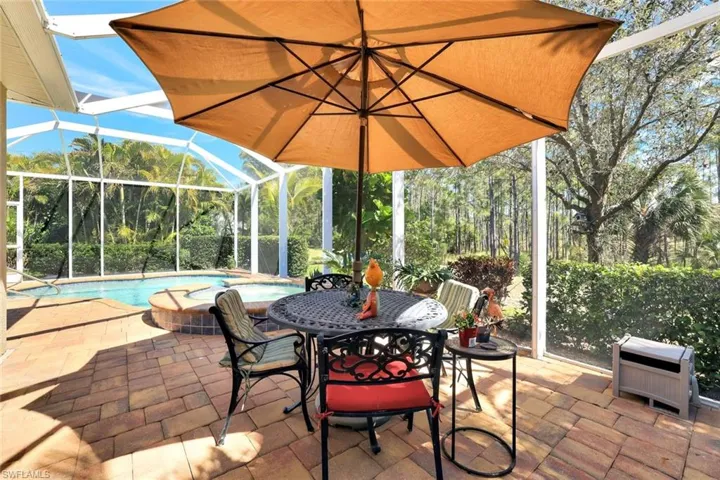 View of patio / terrace featuring heating unit, a lanai, a jacuzzi, and an outdoor pool