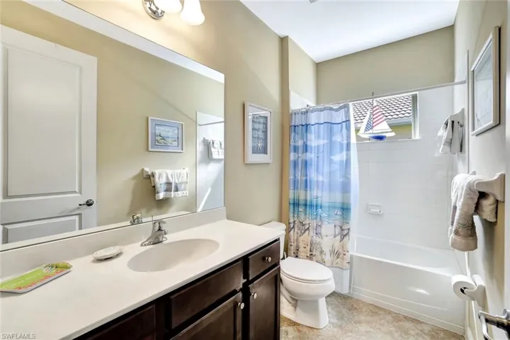 Bathroom featuring toilet, tile patterned flooring, shower / bath combo, and vanity