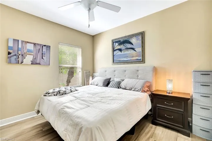 Bedroom featuring light wood-style floors, ceiling fan, and baseboards