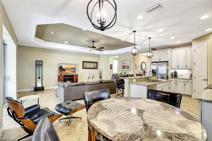 Dining space featuring a tray ceiling, recessed lighting, visible vents, ceiling fan, and baseboards