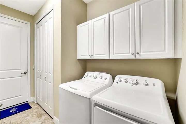 Clothes washing area featuring cabinet space, independent washer and dryer, and baseboards