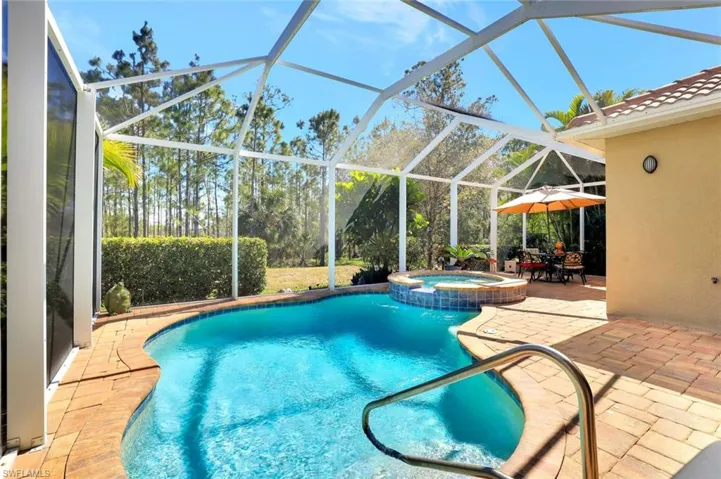 View of swimming pool featuring a lanai, a patio area, and a pool with connected hot tub