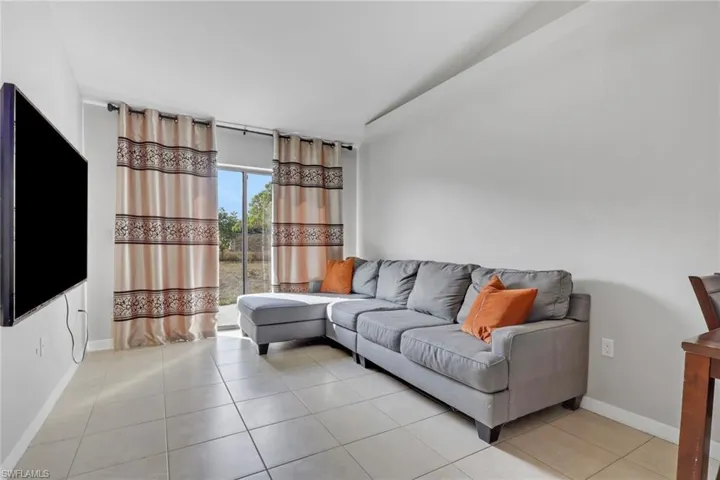 Living room with lofted ceiling and light tile patterned floors