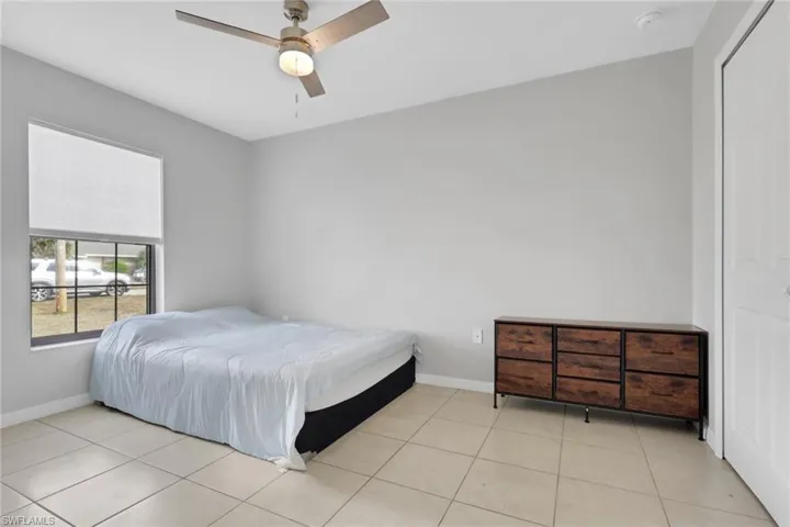 Bedroom featuring ceiling fan, a closet, and light tile patterned floors