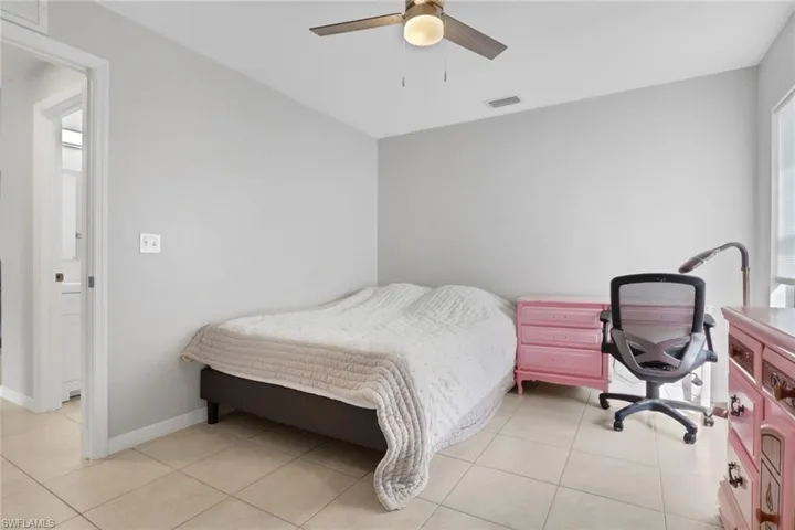 Bedroom with ceiling fan and light tile patterned floors