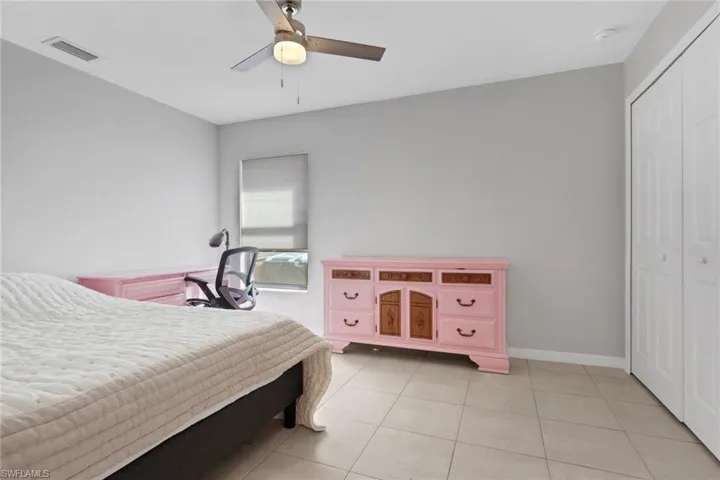 Bedroom featuring ceiling fan, a closet, and light tile patterned floors