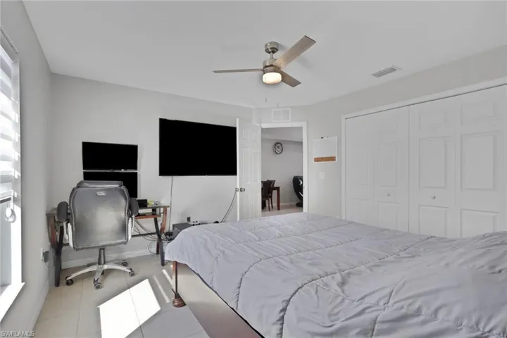 Bedroom with a ceiling fan, an office area, and a closet