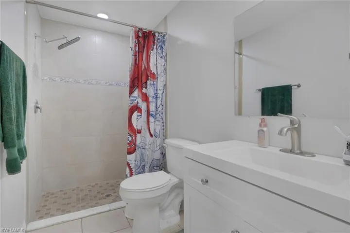 Bathroom with vanity, a shower stall, and light tile patterned floors