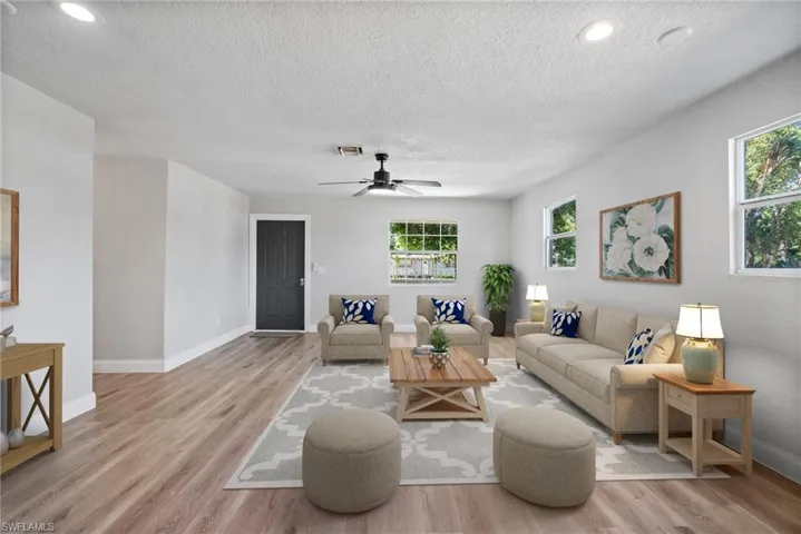 Living room with ceiling fan, light hardwood / wood-style flooring, and plenty of natural light
