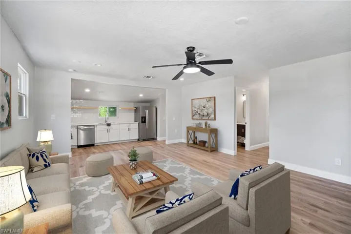 Living room featuring ceiling fan, sink, a textured ceiling, and light hardwood / wood-style flooring