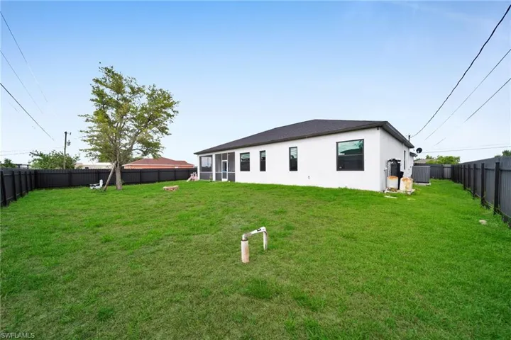 Rear view of house with central air condition unit and stucco siding