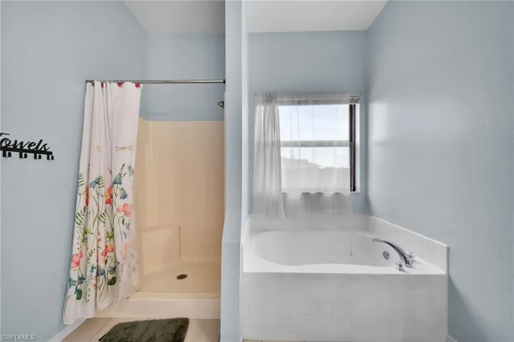 Full bathroom with a bath and a shower with shower curtain
