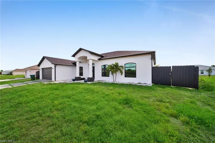 View of front facade with stucco siding, a garage, and concrete driveway