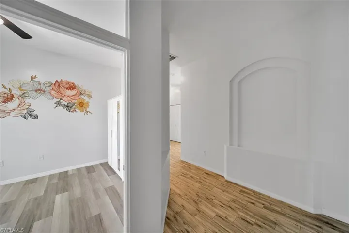 Corridor featuring wood finished floors and baseboards