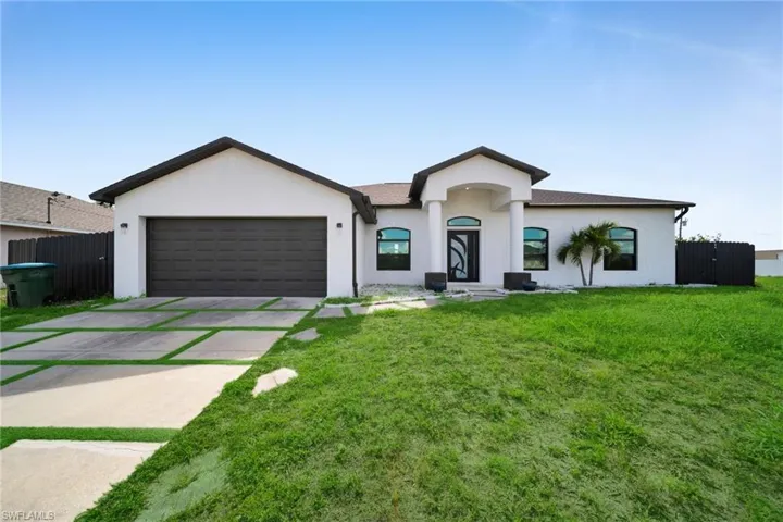 Single story home with a garage, driveway, and stucco siding