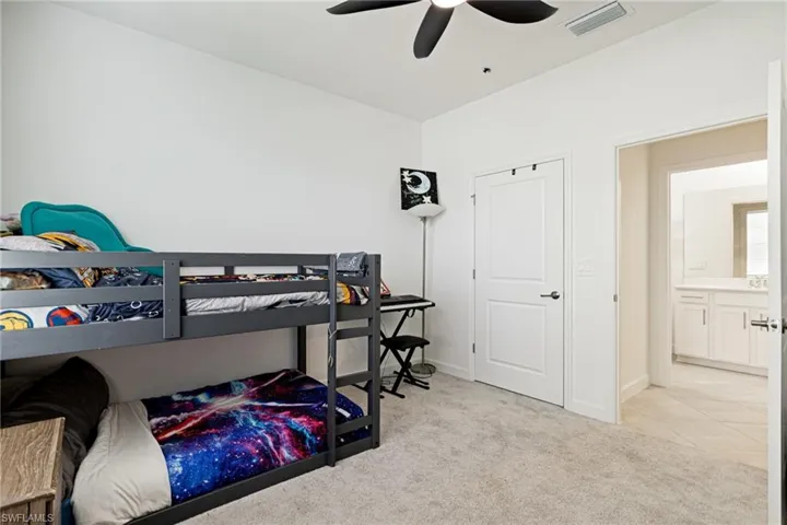 Bedroom featuring light carpet and a ceiling fan