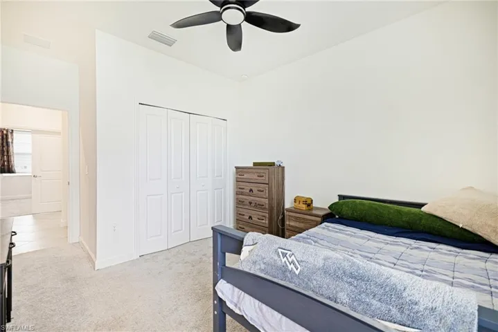 Bedroom with carpet floors, a closet, and ceiling fan