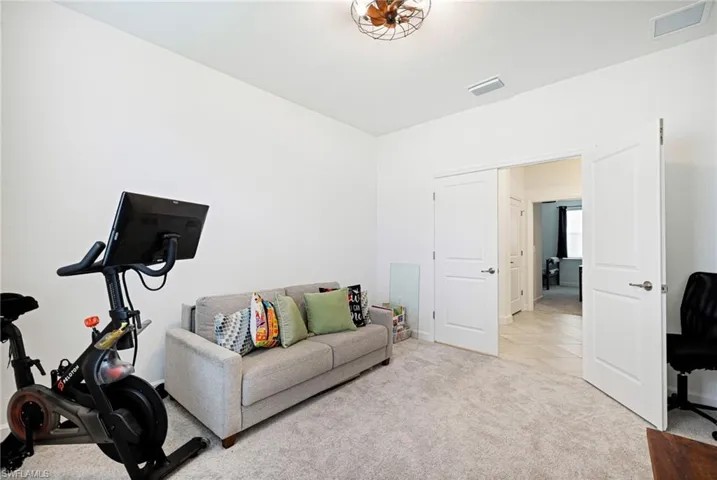 Workout area with light carpet and baseboards