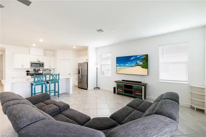 Living area with light tile patterned floors, recessed lighting, and a ceiling fan