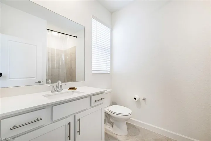 Full bath with vanity, curtained shower, and tile patterned flooring