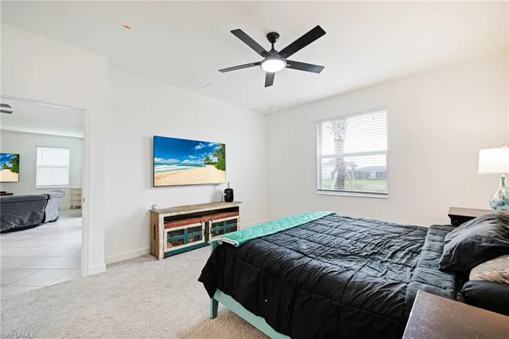 Carpeted bedroom with baseboards and ceiling fan