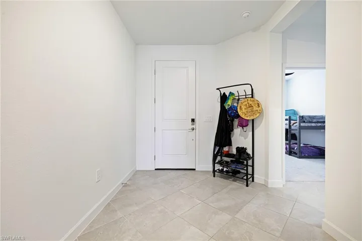 Foyer entrance featuring light tile patterned floors and baseboards
